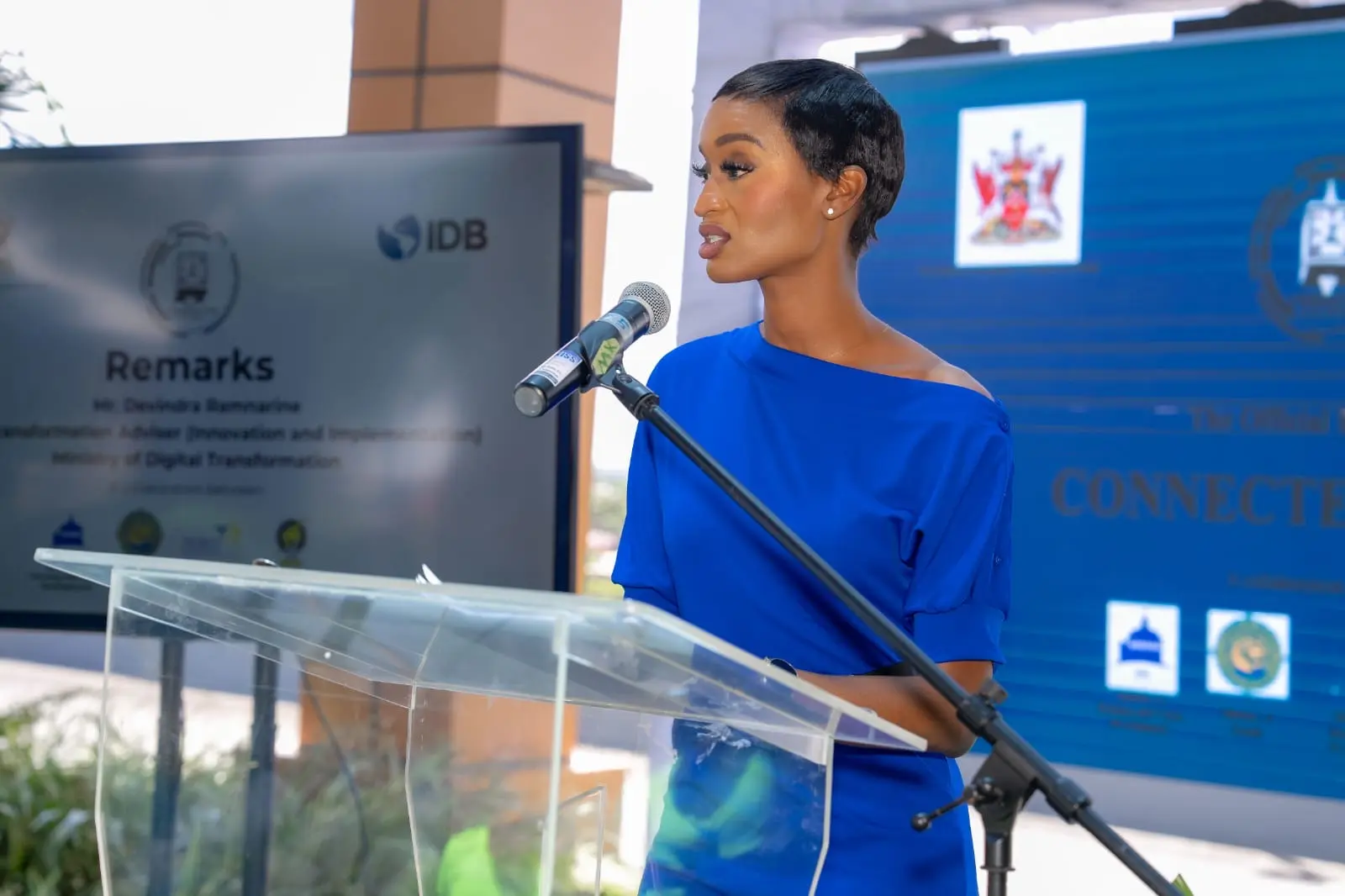 Ainka Will at a podium in a blue dress